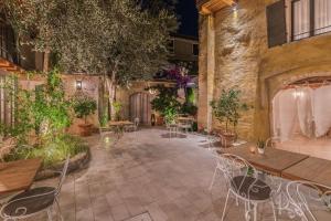 加尔尼亚诺Corte Alma Spa and Luxury Home的一个带桌椅和植物的庭院