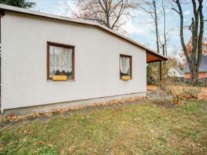 马洛Holiday home with garden in Mahlow Brandenburg的白色的房子,设有两扇窗户和庭院