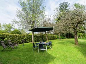 希尼Quaint Cottage in Chiny with Private Garden的草伞下的桌椅