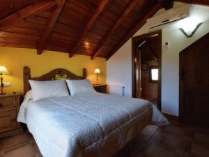 赛阿隆加Belvilla by OYO Villa Javier的一间卧室设有一张大床和木制天花板