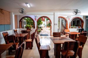 马尔多纳多港Hotel Principe I的餐厅设有木桌、椅子和窗户。