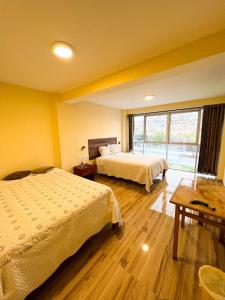 La ApachetaHOTEL DORADO AREQUIPA的酒店客房设有两张床和窗户。