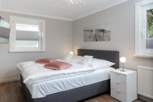 文尼斯塔特Strandhüs Family的卧室配有一张带两个枕头的大白色床