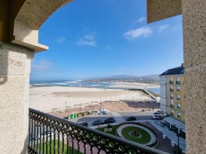 福斯Dúplex en 1ª línea de playa的享有海滩和大楼景致的阳台