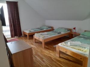 SzelesteAnna Vendégház Szeleste的铺有木地板的客房内的三张床