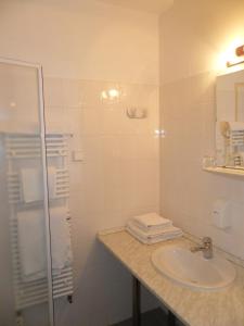 德布勒森斯波特酒店的白色的浴室设有水槽和淋浴。