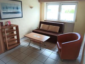 ÜxheimApartment in Leudersdorf Eifel with terrace的客厅配有沙发、椅子和桌子