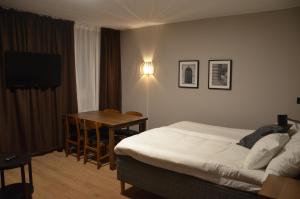 厄斯特松德Hotell Zäta Longstay的酒店客房配有一张床铺、一张桌子和一张书桌。