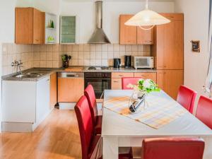 梅德巴赫Splendid Apartment near Ski Area in Medebach的厨房配有白色的桌子和红色的椅子