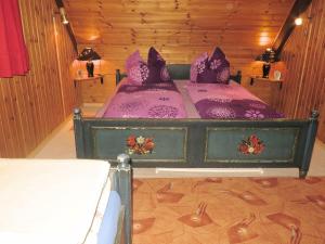 黑林山区圣格奥尔根Holiday home with terrace in the Black Forest的一间卧室配有一张带紫色床单和紫色枕头的床