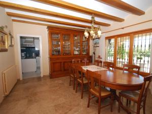 圣塔克里斯蒂纳阿鲁Belvilla by OYO Villa Can Boira的一间带木桌和椅子的用餐室