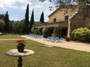 圣塔克里斯蒂纳阿鲁Belvilla by OYO Villa Can Boira的庭院配有椅子和一张带花盆的桌子
