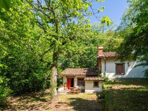 圣马尔切洛皮斯托耶塞Belvilla by OYO Due Camini的树林里有一扇红色门的小白色房子