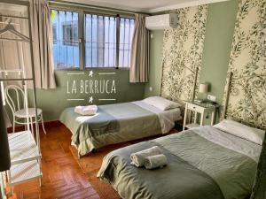 马尔帕尔蒂达德卡塞雷斯La Berruca Casa Rural Malpartida de Cáceres的酒店客房设有两张床和窗户。