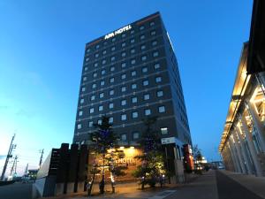 上越市APA Hotel Joetsu Myoko-Ekimae的前面有圣诞树的高楼