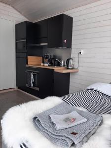 LumijokiWilla Rauha 1B的一间厨房,配有黑色橱柜和一张位于客房内的床