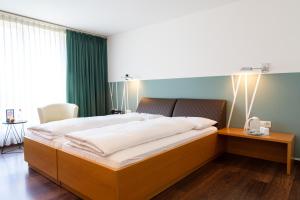 特里森萨兹门酒店的一间卧室配有一张大床和木制床头板