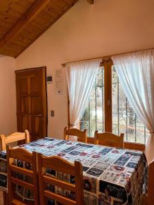 圣卡洛斯-德巴里洛切CABAÑAS MANOLO的一间卧室配有桌椅和窗户。