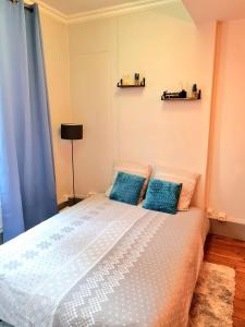 德勒Le Citadin chic的一间卧室配有一张带蓝色枕头的大床