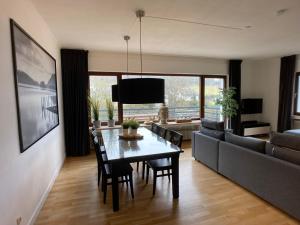 施莱登Villa Holgenbach - Penthouse- und Ferienwohnung im Nationalpark Eifel的客厅配有餐桌和沙发