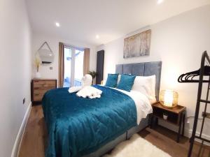 布莱顿霍夫Luxury pad centrally located near Brighton station的一间卧室配有一张带蓝色毯子的大床