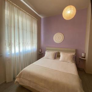 RodelloCascina Beatrice Az Agrituristica的一间卧室设有一张大床和紫色的墙壁