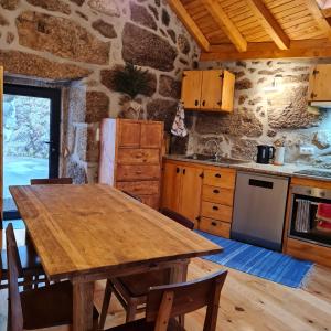 洛里加Casa da Cantareira的厨房配有木桌和石墙