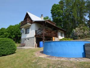 HnaniceHouse with the pool and fenced garden的前面有蓝色围栏的房子