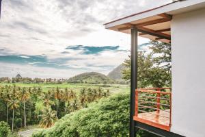 塞隆贝拉纳克Disini Lombok ECO Sky House with Sea view的棕榈树房屋的阳台享有风景。