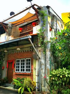 马六甲LEJU 21 樂居 Explore Malacca from a riverside house的一座红砖房子,里面种有植物