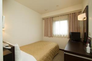 苅田町神田北九州机场阿里斯顿酒店的酒店客房设有床和窗户。