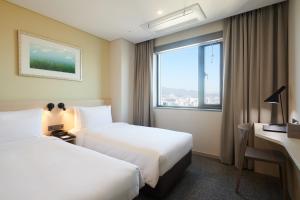 首尔九树酒店东大门 的酒店客房设有两张床和窗户。