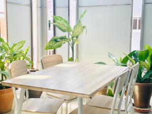 芭东海滩BE Rendez Vous Hotel的植物间里的一张木桌和椅子