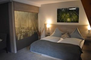 沃尔夫斯堡Hotel Neue Stuben的卧室配有一张床,墙上挂有绘画作品