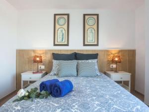 马拉加Holidays2Malaga Mendoza Terrace & Sea View的一间卧室配有一张带蓝色枕头的床。