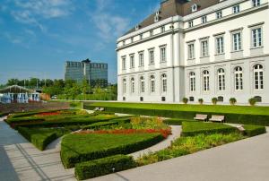 科布伦茨科布伦茨美居酒店的一座白色的大建筑,前面有一个花园