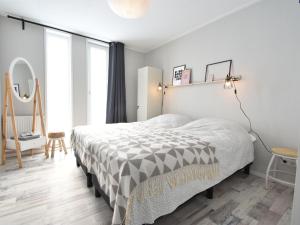 圣安娜兰Classy Holiday Home in Sint Annaland Barbecue的一间卧室配有一张带黑白色棉被的床