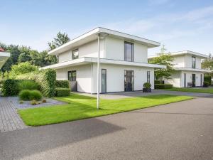 哈尔德韦克Modern Villa in Harderwijk with Sauna and Jacuzzi的白色的房屋,设有绿色草坪
