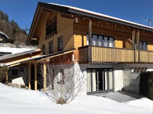 瓦尔高Haus Berglust Wallgau的木屋,在雪中设有阳台