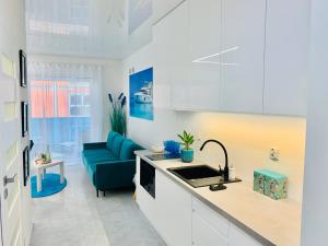 博茨科沃Aquarius Santorini的厨房配有白色橱柜和蓝色沙发