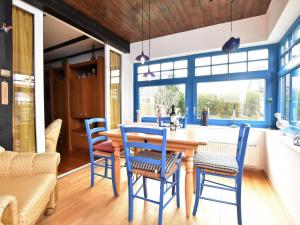 格拉尔-米里茨Holiday home with terrace in Graal M ritz的一间配备有蓝色椅子和木桌的用餐室