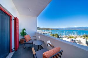 费特希耶Reddoors Suites Sea View的阳台配有桌椅,享有海港的景致。