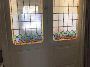 海牙Quietly located mansion near the centre of The Hague的两扇门,两扇门之间设有彩色玻璃窗