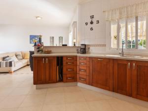 桑卢卡尔-德巴拉梅达Belvilla by OYO Villa Madre del Agua的厨房配有木制橱柜、水槽和沙发。