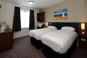 德比Kings Highway, Derby by Marston's Inns的酒店客房设有两张床和窗户。