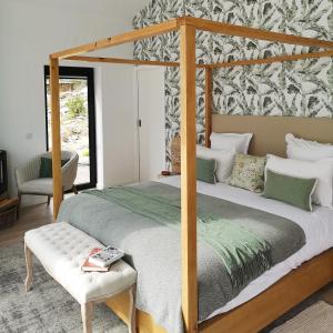Alvoco das VárzeasQuinta das Levadas - Country House & Nature的一间卧室配有一张天蓬床和一把椅子