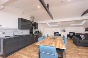 利物浦Concert Square Apartments By Happy Days的厨房以及带木桌和蓝色椅子的用餐室。