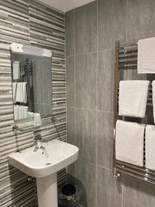 邓弗姆林城市酒店的浴室配有盥洗盆、镜子和毛巾