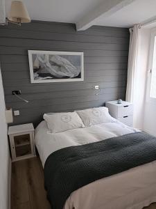 马赛城市之海公寓的卧室配有一张床,墙上挂着一幅画