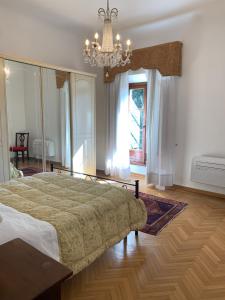 巴尼奥阿里波利Villa Il Padule的一间卧室配有一张大床和一个吊灯。
